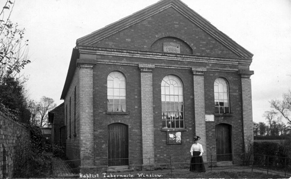 Woman standing outside front of Baptist Tabernacle, early 1900s
